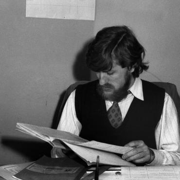 Jūrų skyriaus vedėjas ir Klaipėdos jūrų muziejaus direktorius Aloyzas Každailis prie darbo stalo namelyje (H. Manto g. 14), apie 1970–1975 m. Nuotraukos autorius Vytautas Karaciejus. Lietuvos jūrų muziejus